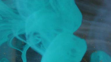 Dikey video. Duman parçacıkları sıçrat. Su bulutu küresi. Odaklanmamış mavi altın rengi sıvı doku soyut arkaplana yayılan toz boyası.