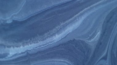 Karışım akışı. Dalgalı mürekkep. Odaklanmamış mavi renkli mermer doku ıslak lekeler su parçacıkları soyut sanat arka planına dökülüyor.