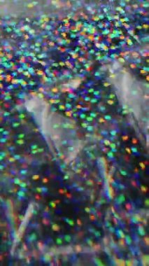 Dikey video. Bulanık çok renkli konfeti. Harika bir üçgen. Sarı turuncu yeşil noktalar parlayan parçalar Bokeh Işığı 'nın soyut arka planında hareket ediyor.