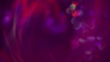 Bokeh çemberi. Bulanık mermi. Çok renkli mor ışıklı lens yanıp sönen desen parıltısı koyu soyut modern arka planda süzülüyor..