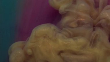 Parıldayan sis. Akış parçacıkları. Soyut akrilik arka planda çözünmüş sarı mor parlak mürekkep kimyasal madde dumanı.