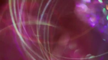 Havai fişekler parlıyor. Bulanık çoklu renk değişimi. Soyut sanat ışığı arka planında süzülen yeşil mor kurdele mercekleri yanıp sönüyor.