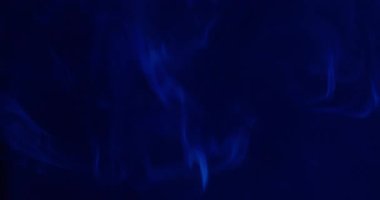 Sis akışı. Renkli duman. Su buharı sisindeki çözünmüş mavi neon mürekkep soyut sanat üzerine yayılıyor koyu siyah akrilik arka plan.