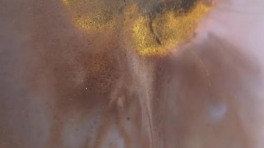 Parıltı dalgası. Mürekkep arkaplanı. Odaklanmamış altın sarısı mavi renkli kimyasal mermer su sıçrama damlası soyut sanata dökülüyor..