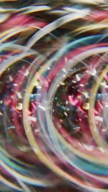 Dikey video. Parıldayan ışık. Bulanık parlayan daire. Çok renkli, ışıl ışıl kırmızı parçacıklar parlak mercek fişeği Bokeh ışığı soyut arkaplanını açıyor.