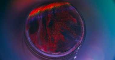 Boya küresi. Parlak. Sızdıran soyut neon akrilik yaratıcı arka planda odaksız kırmızı gökkuşağı yuvarlak emülsiyonu.