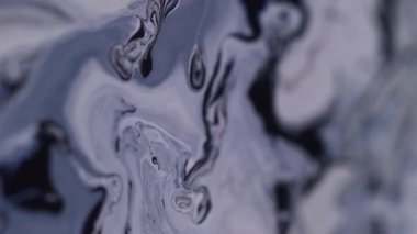 Boya dalgası. Su altı dokusu. Bulanık mavi su, kimyasal sıvı sıçratır. Siyah lekeler soyut koyu ıslak arka planda yayılır..