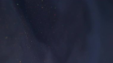 Boya sıvısı. Su altı dokusu. Odaklanamayan mavi köpüklü su kimyasal parçacıkları soyut koyu arkaplan üzerine dökülüyor..