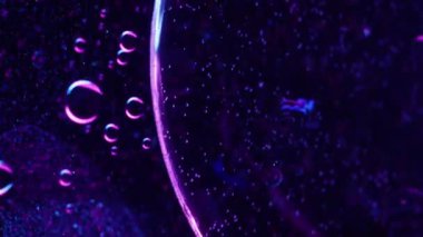 Köpüklü sıvı. Jel serumu. Bulanık mavi neon rengi yağ yuvarlak baloncukları koyu soyut sanat eseri yaratıcı ışık arka planında hareket ediyor.