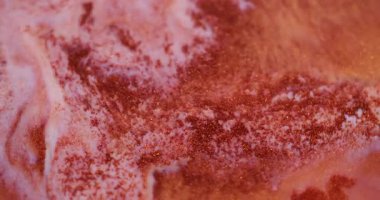 Boya dökülmüş. Su karışımı. Odaklanmamış turuncu bronz renk soyut arkaplanda yüzen parlak sıvı ıslak parçacıklar.