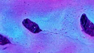 Floresan sıvısı. Boya akışı. Bulanık mor neon renkli su, kimyasal, diş minesi, akrilik kabarcıklar soyut desenli arka plana damlıyor..