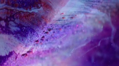 Dikey video. Mistik sıvı. Neon boya. Odaklanamayan parlak mor mor renkli menekşe rengi kübün yüzeyine dökülüyor. Yağlı su pulları soyut arkaplanı karıştırır.