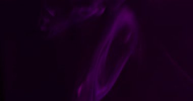 Akrilik duman. Boya dokusu. Odaklanmamış mor neon rengi duman buharı su dumanı yaratıcı soyut siyah arkaplan üzerinde dönüyor.