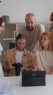 Dikey video. Sahnenin arkasında. Ekip kameramanı. Sanat yönetmeni çalışma stüdyo projesi konseptini açıklıyor. İnsanlar kompozisyon aydınlatma betiğinin teknik özelliklerini tartışıyor.