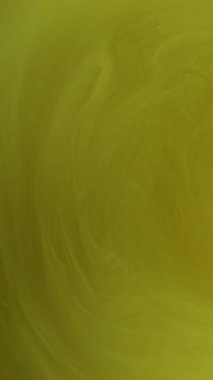 Dikey video. Sarı girdap. Boya sarmalı. Renkli sıvıdan dumanlı dokuya sahip çözünmüş dalgalı girdap dönüşü. Sıvı sihirli mermer boya akış arkaplanı.