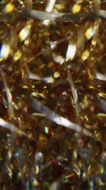 Dikey video. Bulanık parıltı parlaması. Parlak ışık. Parlak altın sarısı çok renkli parçacıklar. Soyut sanat arka planında hareket eden parlak mercek parlamaları..