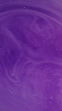 Dikey video. Renk bulanıklığı. Bulanık girdap. Parıldayan leylak rengi mor su parçacıkları parlak boya sıvısı soyut arkaplanda hareket ediyor..