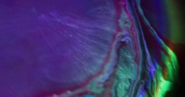 Sıvı karışımı. Akan mürekkep. Odaklanmamış mavi yeşil renkli gökkuşağı kimyasal mor kırmızı parlak su soyut neon ışık arka planında yüzüyor..