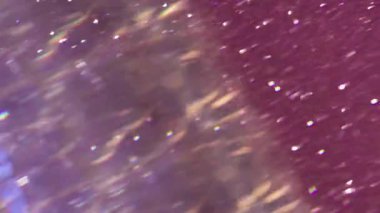 Işın titreşimi. Odaklanamayan renkli işaret fişeği. Açık yeşil, mor mavi soyut arkaplan üzerinde bulanık beyaz parçacıklar.