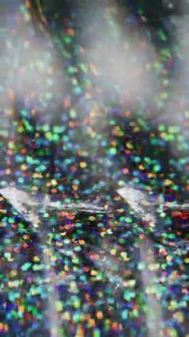 Dikey video. Konfeti örtüsü. Bulanık ışık. Renkli kırmızı, sarı, ışıl ışıl parçacıklar, ışık saçan mercekler, arka planda bokeh efektiyle yanıp sönüyor..