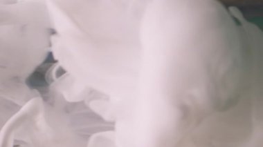 Dikey video. Su dumanı. Boya sıçraması. Soyut yaratıcı sanat arka planında yüzen beyaz renkli sis sıvısı dokusu piramidi.