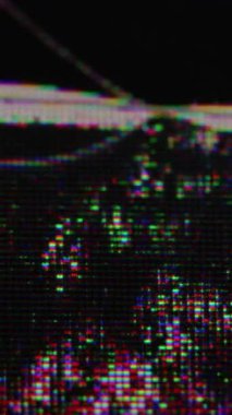 Dikey video. Arıza bulanıklığı. Kırık pikseller. Hasarlı LCD ekranın siyah ıslak yüzeyi ve renkli tanecikli başarısız noktalar. Parlak matris çiziği.