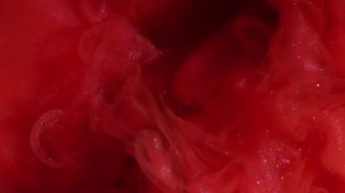 Işıl ışıl. Sanat sıvısı. Siyah su yüzeyinde kırmızı parıldayan boya karışımı patlaması. Soyut toz duman sızıntısı çözünmüş arkaplan.