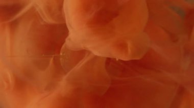 Dikey video. Duman sıçratma boyası. Top arka planda. Soyut yaratıcı sanatta odaklanmış turuncu renkli su yuvarlak doku sıvı dalgası.