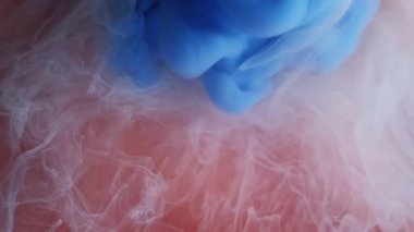 Sihirli buhar Boya patlamış. Kahverengi beyaz sıvıya yayılmış mavi puf spreyi. Soyut su rengi patlaması fantezi arka planını bulanıklaştırır.