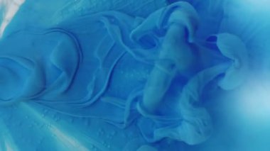 Dikey video. Pürüzsüz sis. Boya sızıntısı. Havadar mavi sanat damlası sıvı girdap dalgası cam üzerine dökülmüş gümüş elmas soyut buhar arka planı.