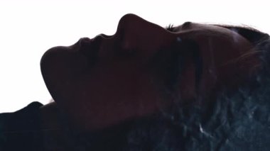 Dikey video. Aydınlanma enerjisi. Ruhsal iyileşme. İç huzuru. Etkilenen kadın, beyaz renkte yüzen parıltılı tozla çifte maruz kalıyor..