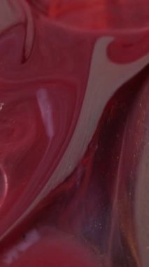 Dikey video. Mermer emülsiyon boyası. Renk akışı. İndirme işlemi tamamlandı. Altın kırmızısını karıştıran parıltı. Spiral jet yakın plan. Sanatın genişlemesi su dönüşümü. Işıldayan sıvı.