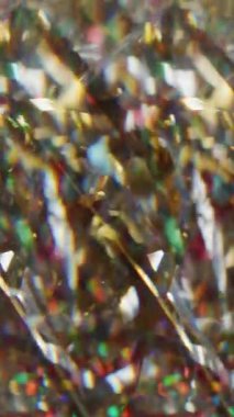 Dikey video. Renkli konfeti. Görüntü cazibesi bokeh. Parlayan kırmızı yeşil parçacıklar parlak yanıp sönen kıvrımlar soyut ışık arka planında hareket ediyorlar..