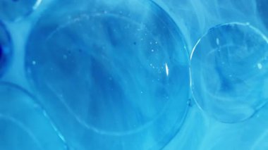 Parıldayan parçacıklar. Sıvı jel. Odaklanmamış mavi renk moleküler boya lekeli asit su akışı soyut sanat akrilik arka planda yayılıyor.