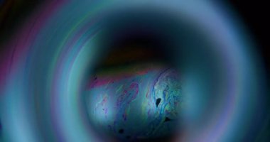 Mürekkep lekesi dökülmüş. Baloncuk gezegeni. Renk sıvısı parlayan küre. Kozmik mavi dünya benzini soyut çerçeve siyah arkaplan.