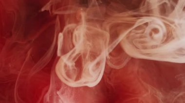 Buhar mürekkebi. Sis boyası. Siyah arkaplanda süzülen sarı turuncu sis örtüsü parçacıkları. Renkli kıvrımlı bulut suyu soyut sihirli bulanık duman.