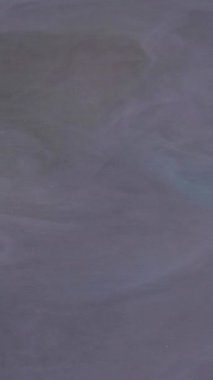 Dikey video. Yumuşak akış. Renkli dalga boyası. Odaklanmamış bulut sisi sıvı duman tüten parlak sıçrayan mürekkep soyut sanat arka planında yüzüyor..