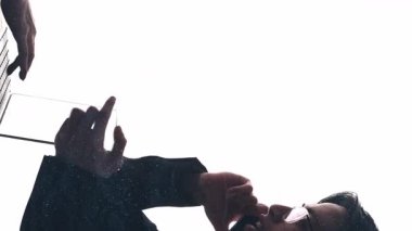 Dikey video. Şirket yardımı. Akıllı iş. Parıltı tozu çift pozlama profil silueti beyaz kopya boşluğunda izole edilmiş telefon dizüstü bilgisayarı kullanarak çalışan çeşitli takım.