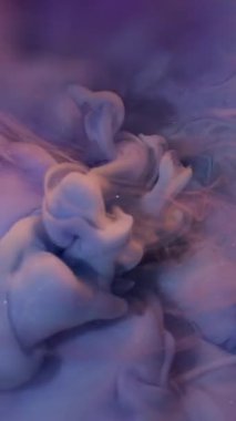 Dikey video. Boya bulutu. Çoklu renk akışı. Tuhaf mor bukleler mistik ışıltılı yanardöner karışımı soyut su arka planında.