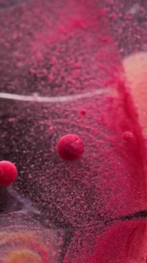 Dikey video. Toz sıvısı. Parıldayan baloncuk. Renkli jel boya damlaları. Renkli boya. Renkli boya karışımı..