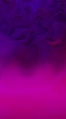 Dikey video. Duman patlaması. Yuvarlak mercek. Pembe parlak sıvıya yayılan mor mürekkep lekeli sis akışı fantezisi. Çember kiriş ışığı soyut arka planı .