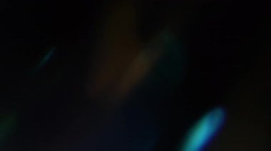 Parıltı. Bulanık optik sızıntı. Odaklanmamış mavi, sarı, altın renkli lens soyut koyu siyah arkaplan üzerinde parıltı deseni..