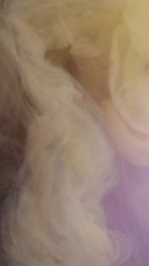 Dikey video. Sis sıvısı. Kozmik akış. Açık bej rengi boya, koyu gizemli su soyut arka planda salınır. İpek suluboya sisli, odağını kaybetmiş bukleli pırıltılar..