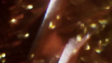 Üçgen parlıyor. Odaklanamayan el feneri. Yeşil mavi, mor, çok renkli, pırıl pırıl bir lens. Bokeh efektli, soyut, bulanık bir arkaplanda parıldıyor..