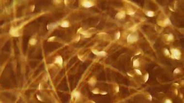 Parlayan çelenk. Odaklanamayan altın parıltı. Işıl ışıl sarı, yanıp sönen daireler soyut Bokeh üzerinde hareket ederken modern arka plan bulanıklaştı..