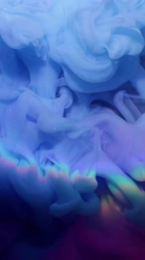 Dikey video. Renkli sis. Boya dumanı. Tuhaf, ışıl ışıl, parlak neon bir sıvı. Soyut, karanlık arka planda parlıyor. Su, dairesel lensleri çözüyor..