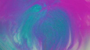 Mürekkep sıçraması. Bulanık boya karışımı. Akrilik sıvıda parlak renkli pigment damlası dökülmüş. Pembe beyaz mavi parıldayan akış soyut arkaplan.