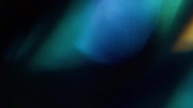 Bokeh fişeği. Bulanık çember parlıyor. Odaksız mavi, altın sarısı, yanıp sönen mercek soyut sanat, koyu siyah arkaplan..