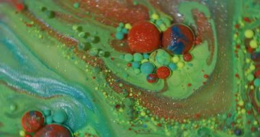 Mürekkep parçacıkları. Suyu boya. Odaklanmamış yeşil mavi parlak yağ sarı turuncu damlacıklar soyut arkaplanda ışıldayan sıvılar