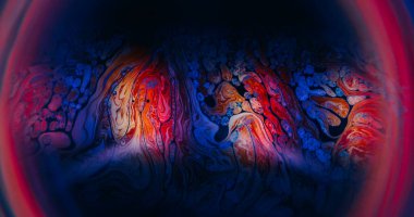 Sıvı alev dokusu. Odaklanmamış mürekkep karışımı. Renkli boya ışığı emülsiyonda akıyor. Kırmızı mavi turuncu pigment neon çerçeve soyut siyah arkaplan.